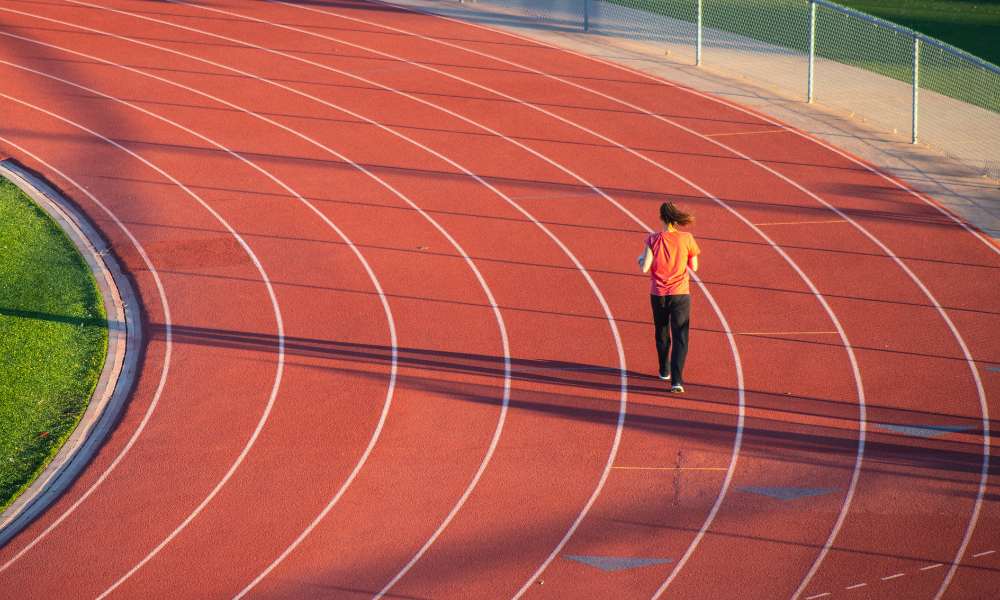 Instalación deportiva de atletismo con una persona entrenando en ella